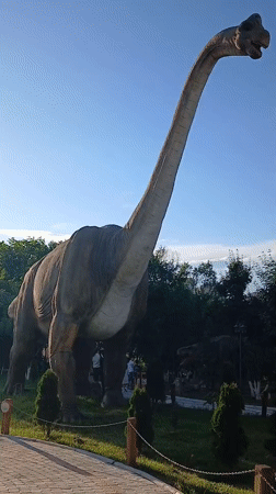 Exploring an outdoor dinosaur park with statues and live animals