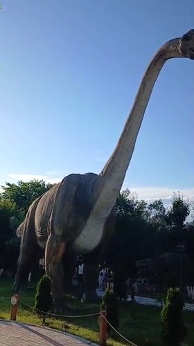 Exploring an outdoor dinosaur park with statues and live animals