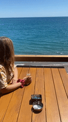 Woman enjoys champagne oceanside in Sutomore, Montenegro