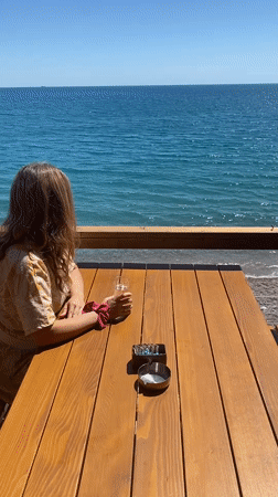 Woman enjoys champagne oceanside in Sutomore, Montenegro