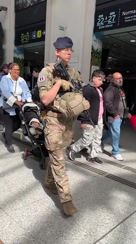 Armed soldier patrols busy Paris transit hub during morning rush