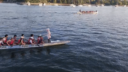 Dragon boats, kayaks, and ferries on a lively urban waterfront