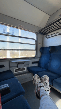 Train passenger rests feet on seats in rural Bulgaria