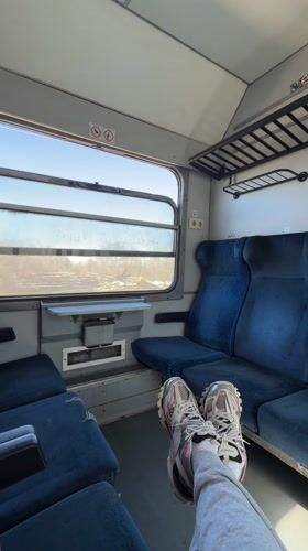 Train passenger rests feet on seats in rural Bulgaria
