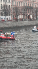 Small boats navigate Saint Petersburg waterways on overcast morning