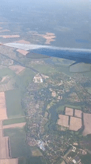 Passenger documents commercial flight journey with aerial city views