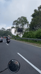 Morning traffic rolls through a green-lined road in Ngluweng