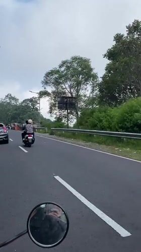 Morning traffic rolls through a green-lined road in Ngluweng