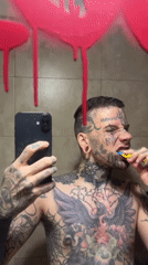 Tattooed man multitasks with phone while brushing teeth in Argentina