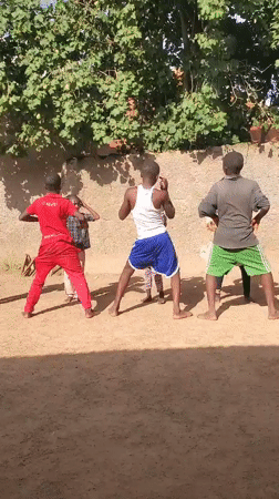 Kids play, drum, and dance in a Jos, Nigeria courtyard