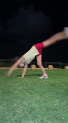 Cartwheels and tumbling on a grassy lawn in Netanya at night