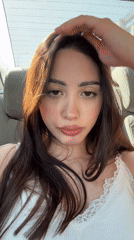 Woman in white tank top sits in car, Yerevan