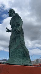 Tourists document statue, coastline during afternoon in Las Palmas