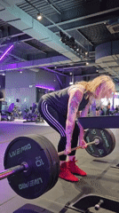 Woman performs deadlift workout at gym