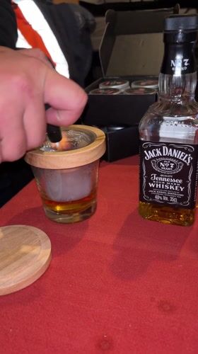 Bartender prepares smoked Jack Daniels cocktail in Den Haag