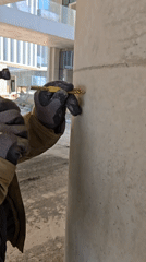 Worker performs maintenance on concrete pillar in Ramat HaSharon