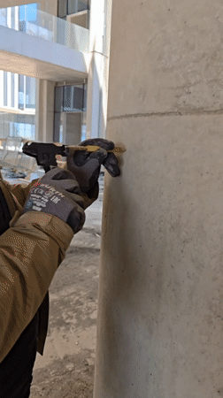 Worker performs maintenance on concrete pillar in Ramat HaSharon