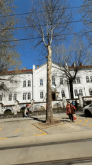 Pedestrians filmed walking past white building in Belgrade