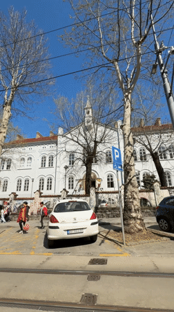 Pedestrians filmed walking past white building in Belgrade