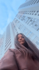 Woman photographed from low angle near Krasnogorsk high-rise building