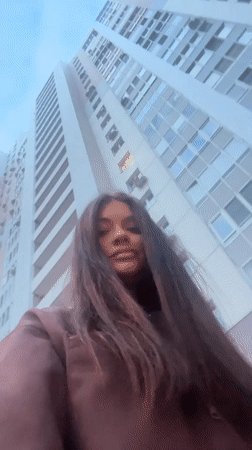 Woman photographed from low angle near Krasnogorsk high-rise building