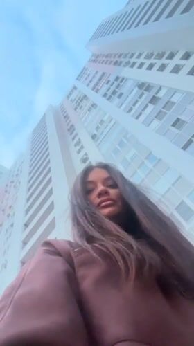 Woman photographed from low angle near Krasnogorsk high-rise building