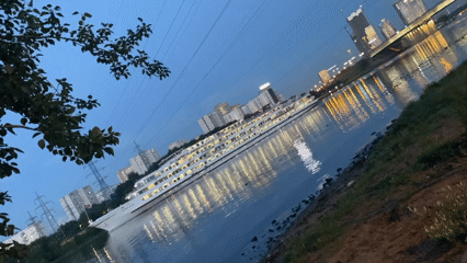 Dusk on the Moscow Canal: docked ship, city lights, waterfront path