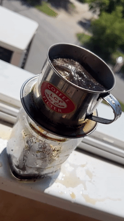 Vietnamese phin coffee brewing slowly into a glass jar