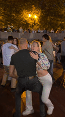 Couples dance on a Moscow riverside promenade at midsummer dusk