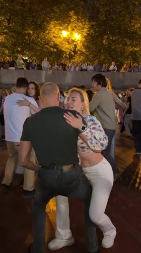 Couples dance on a Moscow riverside promenade at midsummer dusk