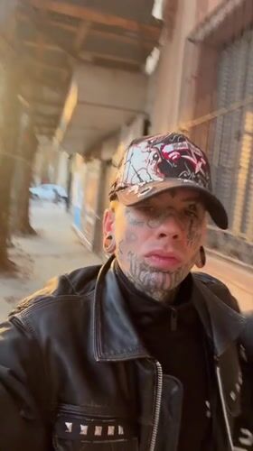 Tattooed person films self near Gothic church in Buenos Aires