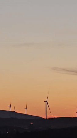 Golden hour over Seferihisar, turbines and minarets at dusk