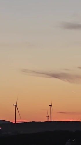 Golden hour over Seferihisar, turbines and minarets at dusk