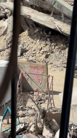 Child plays on swing amid rubble in Gaza