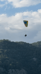Paragliders spotted over forested mountains in Fethiye, Turkey