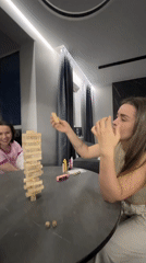 Friends Play Jenga During Indoor Birthday Celebration