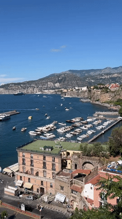 Tourists document sunny afternoon views across Sorrento's coastline and landmarks