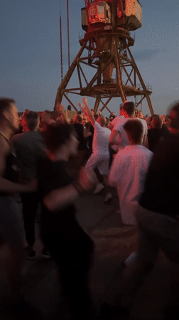 Outdoor dance party glows under pink and red lights in Riga