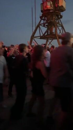 Outdoor dance party glows under pink and red lights in Riga