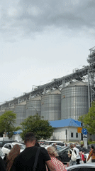 Crowds with luggage walk past grain silos in Novorossiysk
