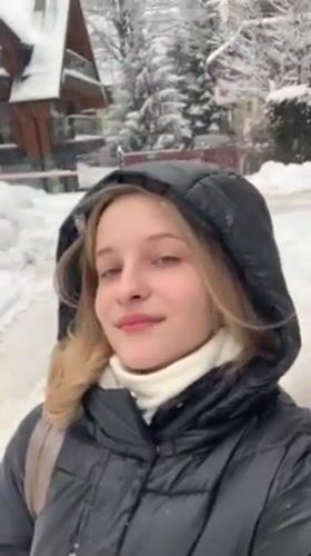 Woman films herself in snowy Zakopane street scene