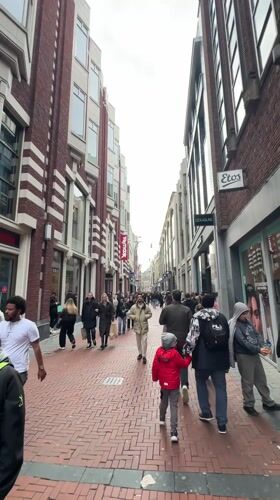 Woman films herself walking Amsterdam pedestrian street