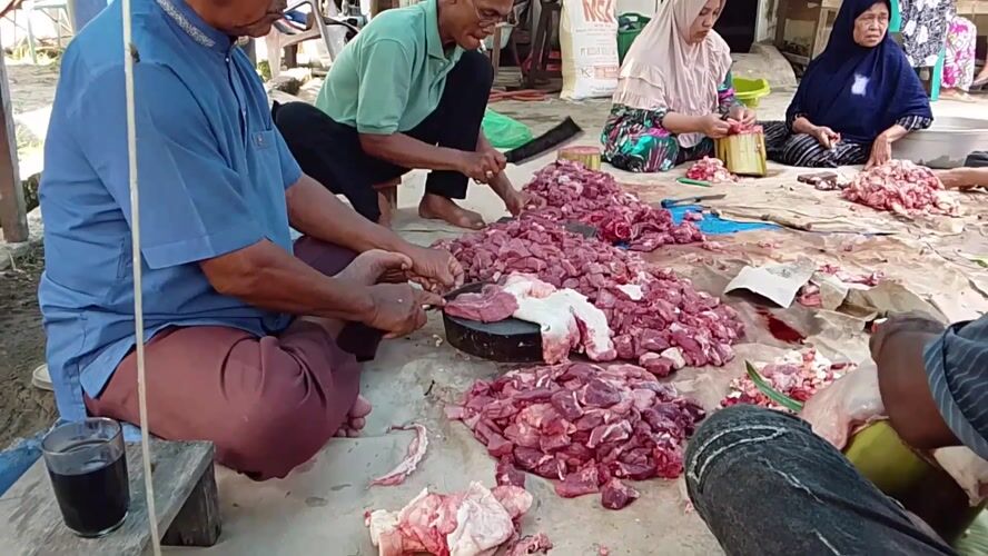 Early morning communal meat preparation and cooking in Gampongjawa