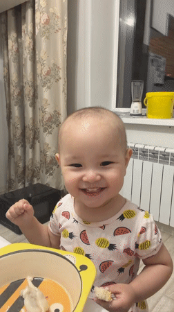 Toddler enjoys mealtime at home in Astana, Kazakhstan