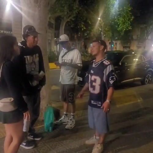 Young people skateboard and socialize on Barcelona streets at night