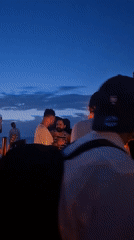 Evening outdoor party with DJ draws crowd under blue skies