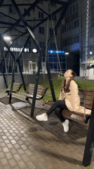 Woman explores wet nighttime Chaikovsky near church and bear topiary