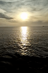 Golden hour on the Lhokseumawe coast, boats on the horizon