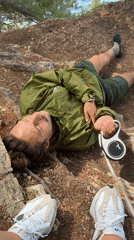 Man with dog leash rests on cliff overlooking Adriatic