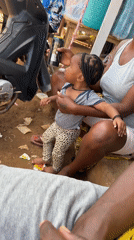Woman holds baby and Guinness can in Kurunduma, Nigeria
